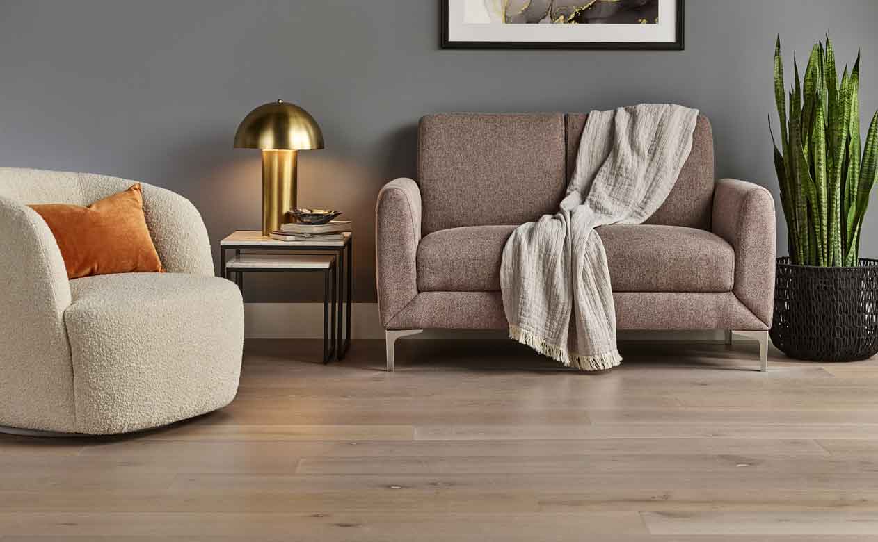 hardwood flooring in a living room with a love seat and accent chair